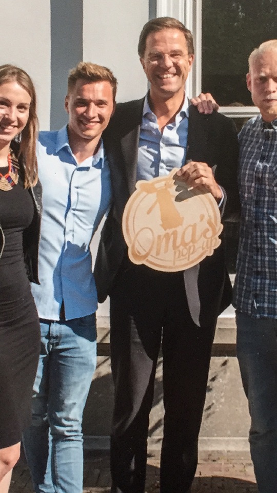 Mark Hendriks with the Dutch Prime Minister and colleagues, holding an Oma's Pop-up sign